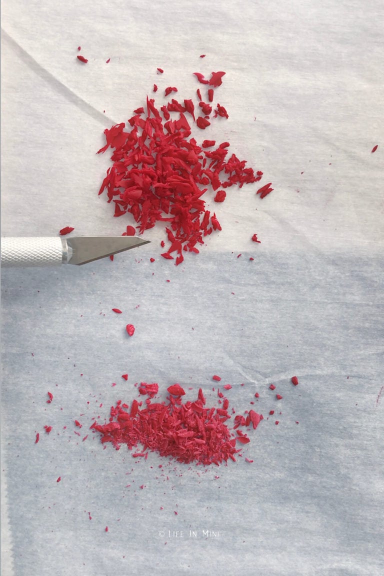 Red clay shavings of two different sizes on a white parchment paper