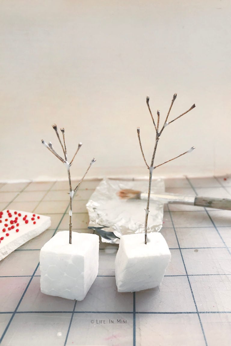 Twigs brushed with watered down glue stuck into styrofoam cubes waiting to dry