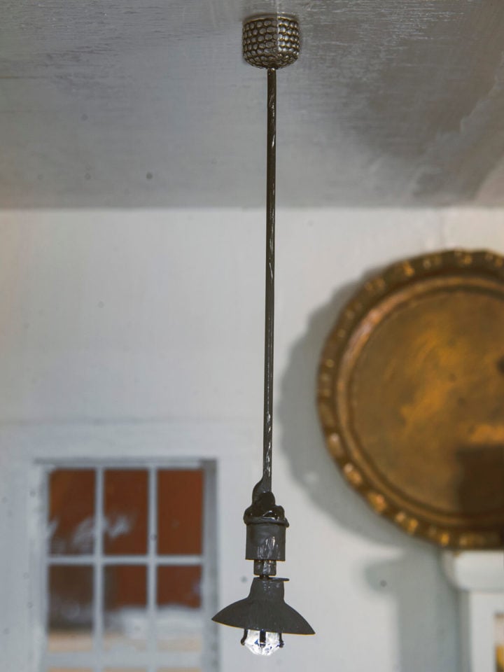 Closeup of a mini dollhouse pendant light hanging from the ceiling