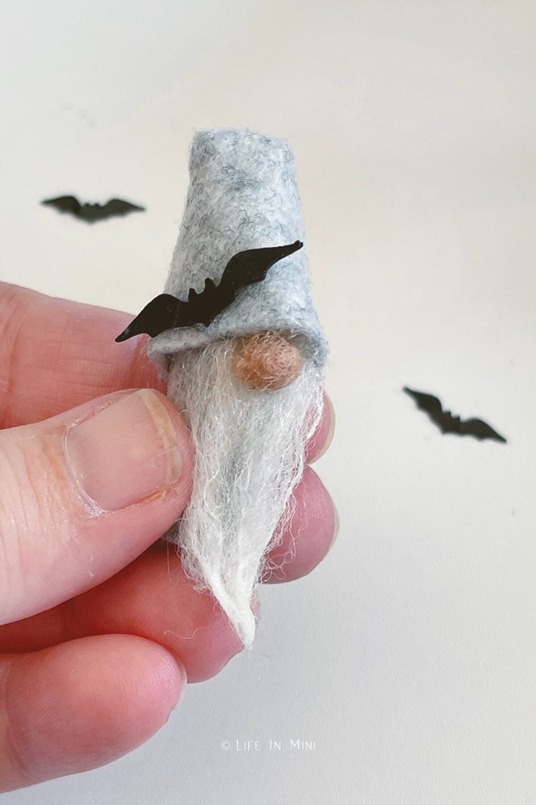 Adding bats to the hat of a mini halloween gnome