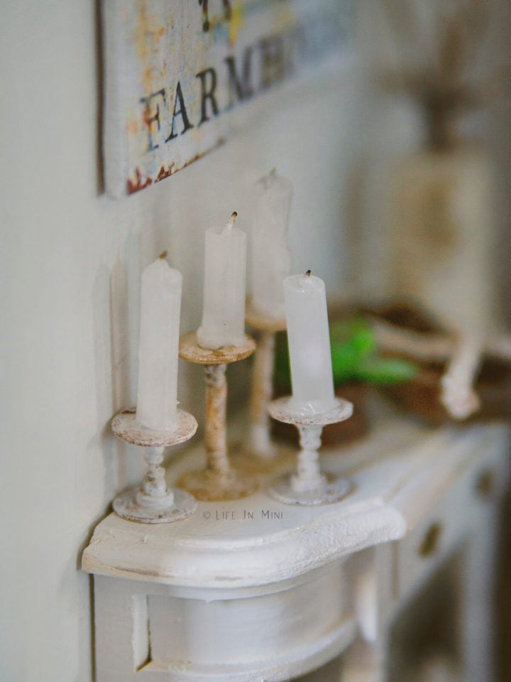 Closeup of miniature candles and candlesticks