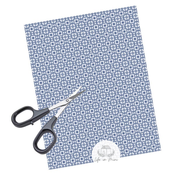 A sheet of blue square geometric miniature dollhouse tile in 1:12 scale with scissors