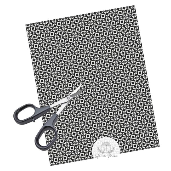 A sheet of black square geometric miniature dollhouse tile in 1:12 scale with scissors