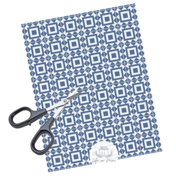 A sheet of blue square geometric miniature dollhouse tile in 1:6 scale with scissors