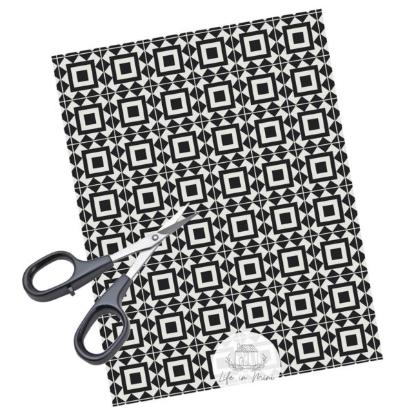 A sheet of black square geometric miniature dollhouse tile in 1:6 scale with scissors