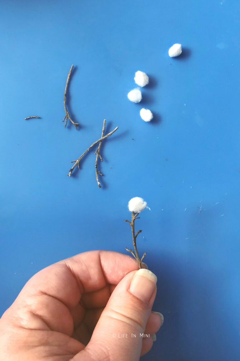 Gluing mini cotton balls onto sticks