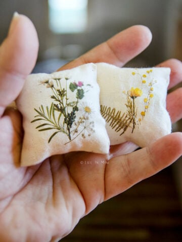 Closeup of two miniature pillows with rub on transfer flowers on them