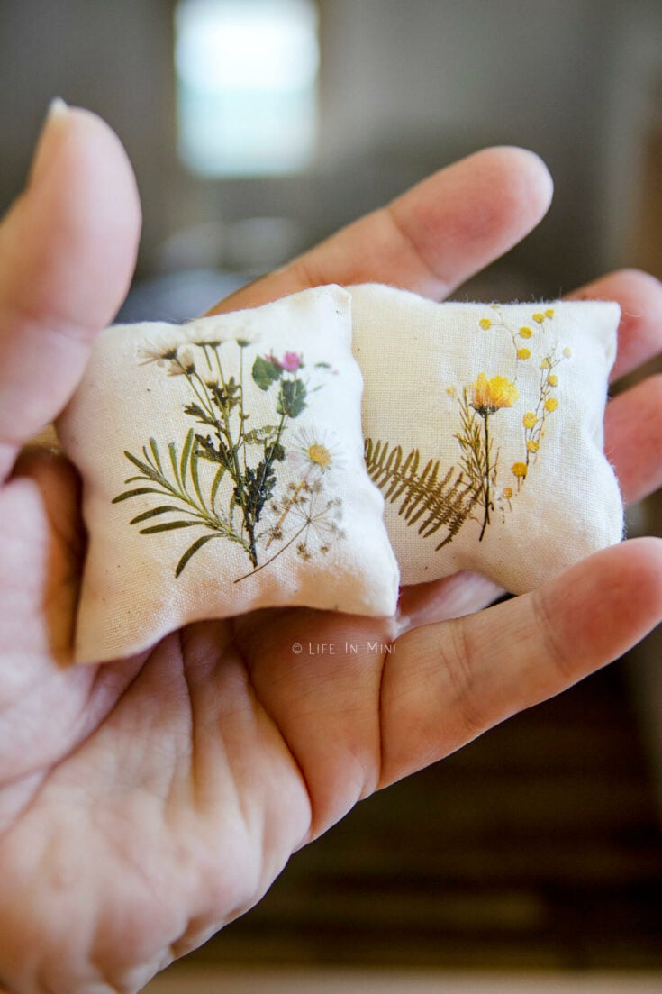 Closeup of two miniature pillows with rub on transfer flowers on them