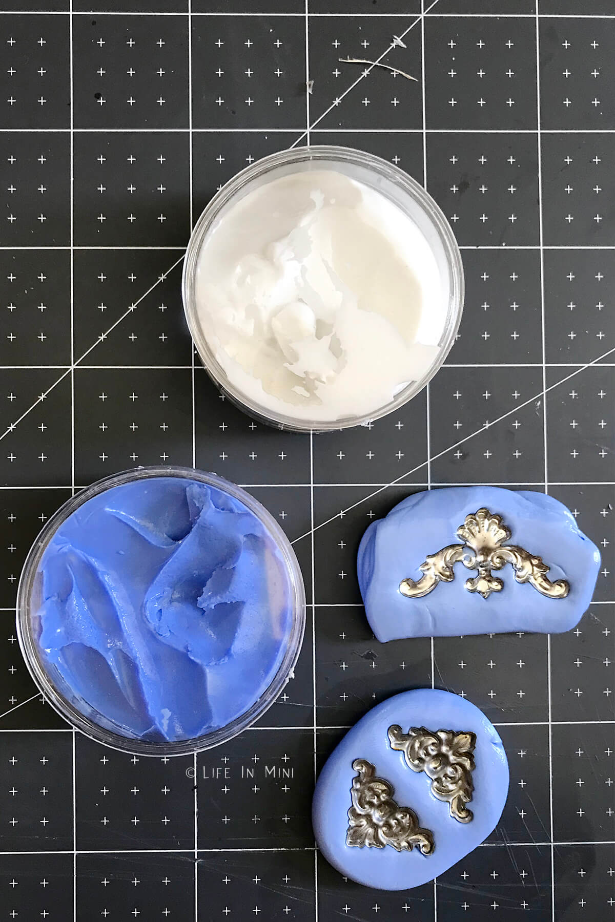 Molding putty in blue and white with ornamental pieces pushed into two pieces of putty