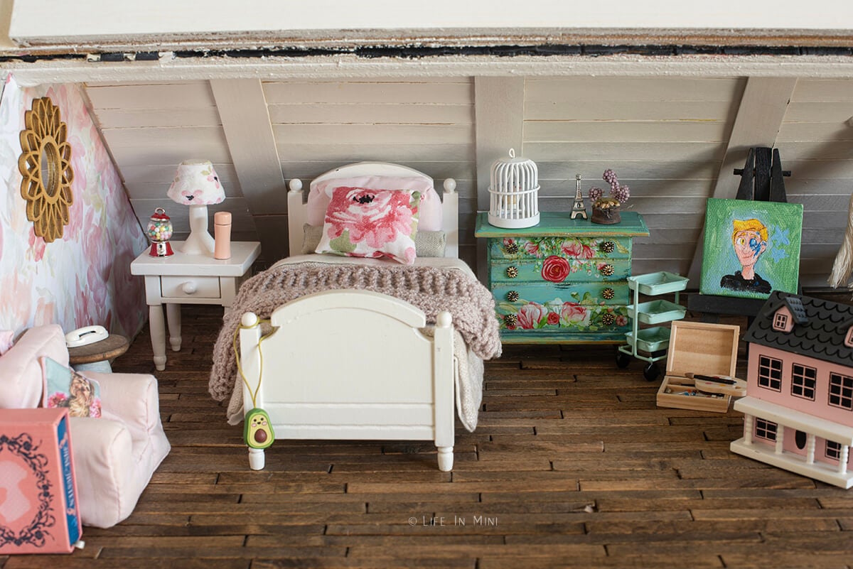 A dollhouse attic decorated to be a young girl's bedroom