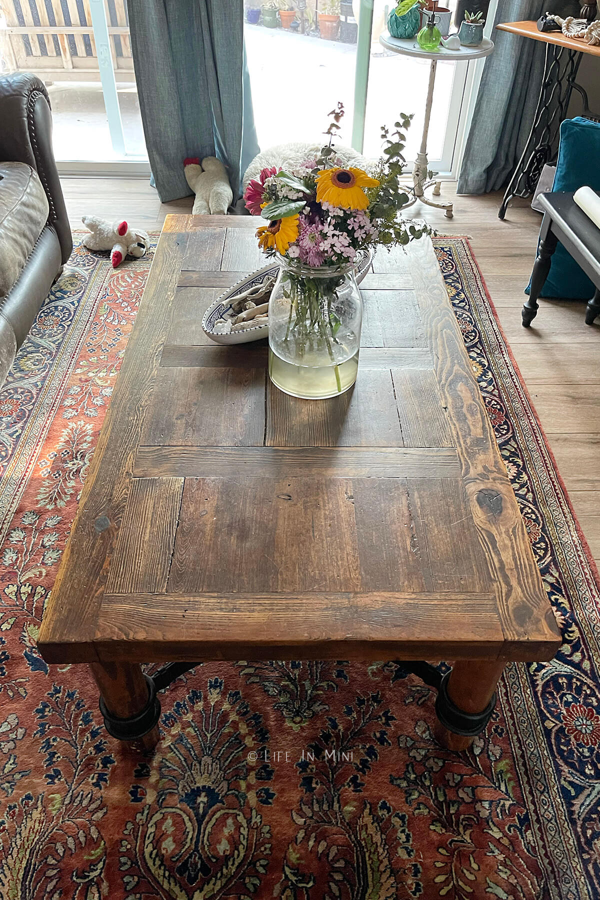 A dark wood coffee table in a living room before it the wood was bleached