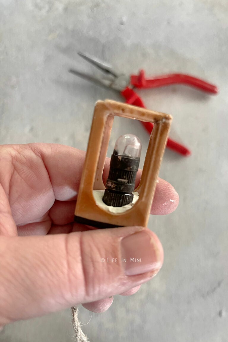 Side view of a balloon light pressed into air dry clay inside a miniature lantern