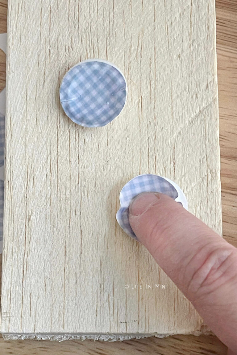 Pressing miniature blue paper rounds into pull tab discs