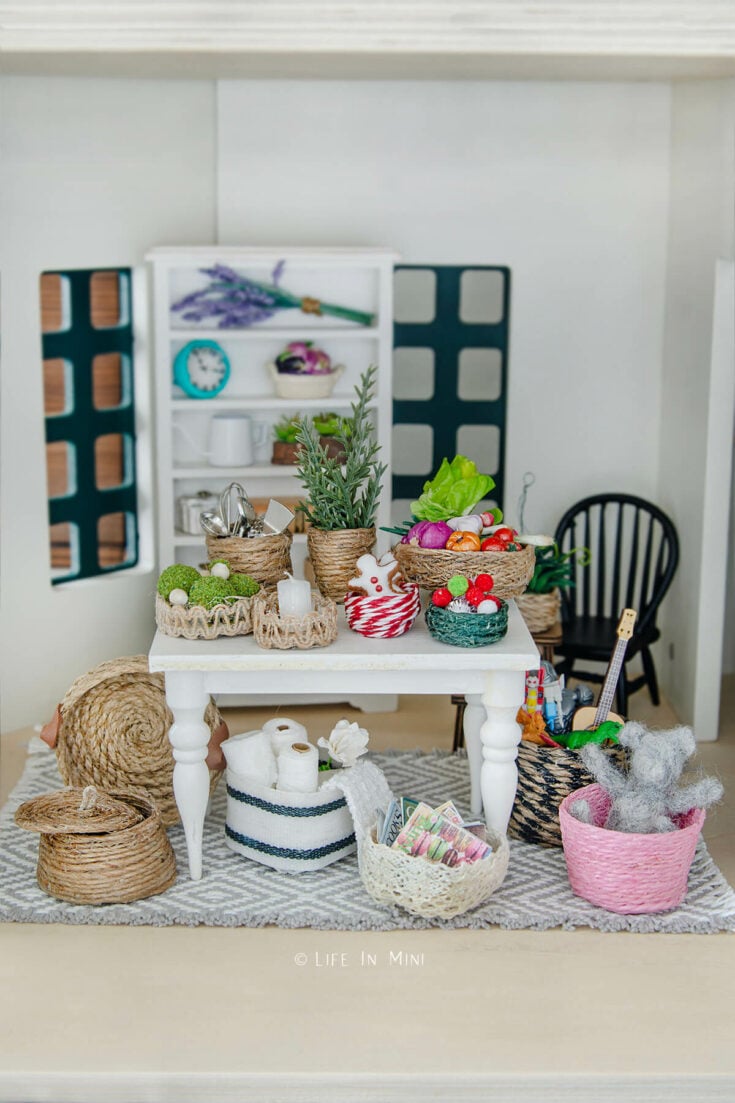 A dollhouse table with assorted mini baskets on it and around it filled with various accessories