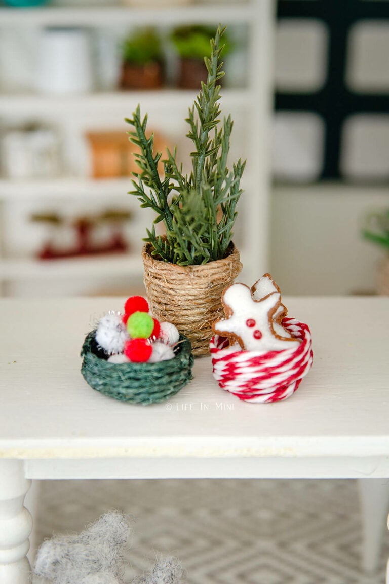 Three Christmas themed mini baskets on a white dollhouse table