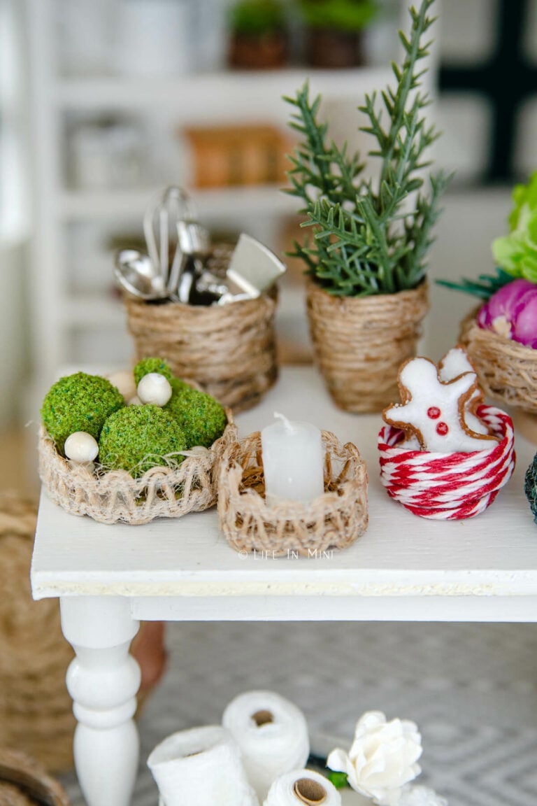 Various mini baskets with a closeup of one filled with mini moss balls and another with a mini candle