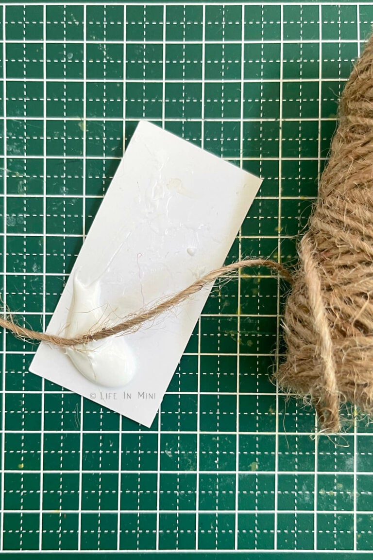 A small piece of paper with white glue and twine on it