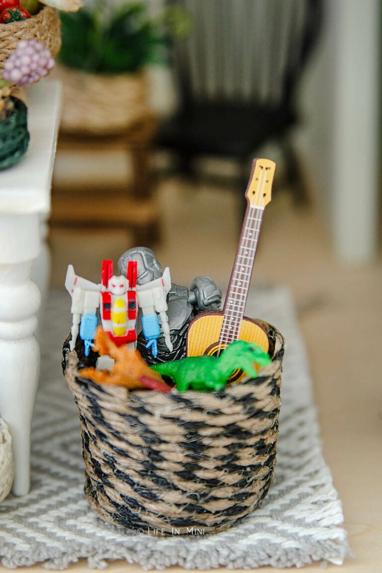 A black and twine mini toy basket filled with miniature toys