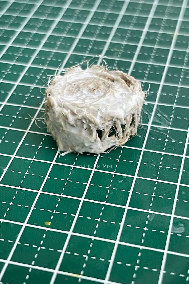 A small twine and burlap bowl covered in glue drying on a small cutting mat