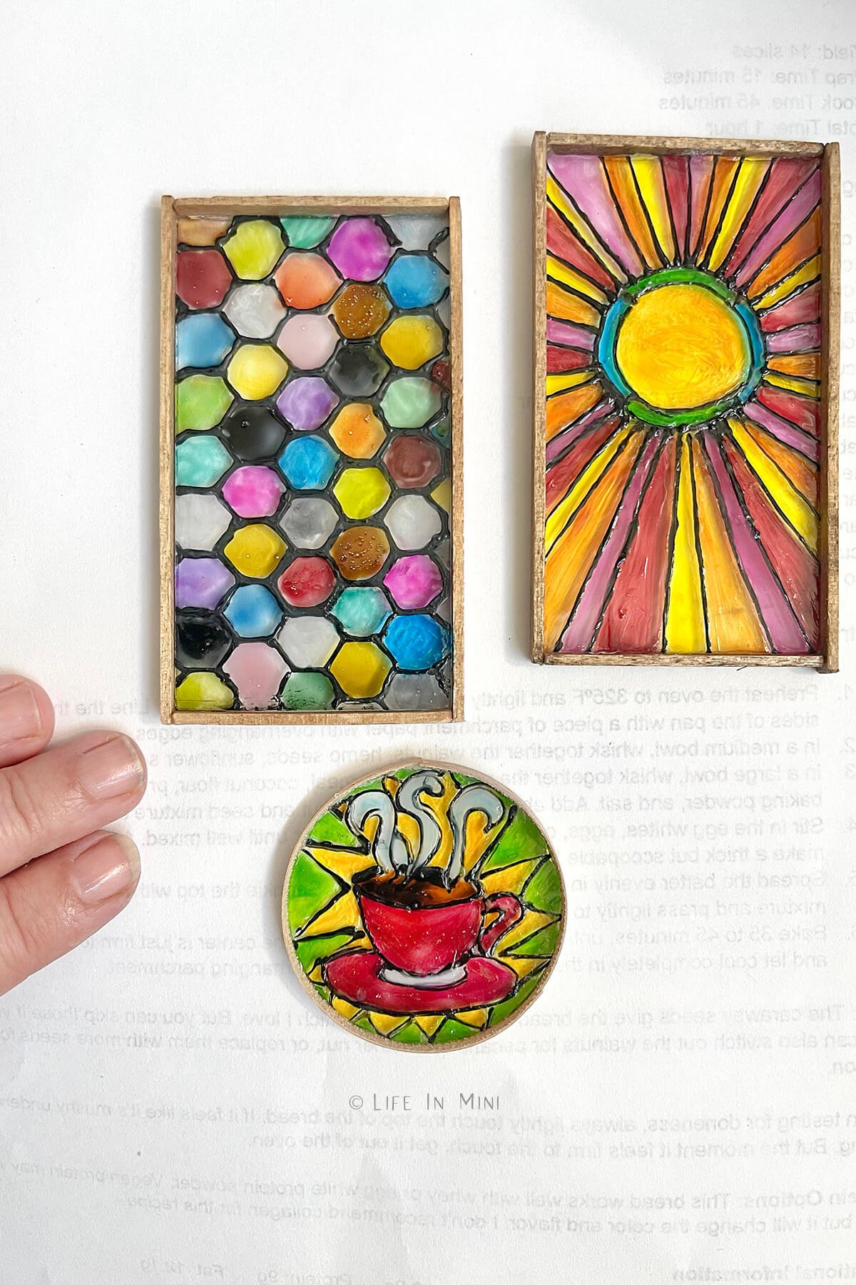 Three miniature stained glass pieces of different designs and framed in wood