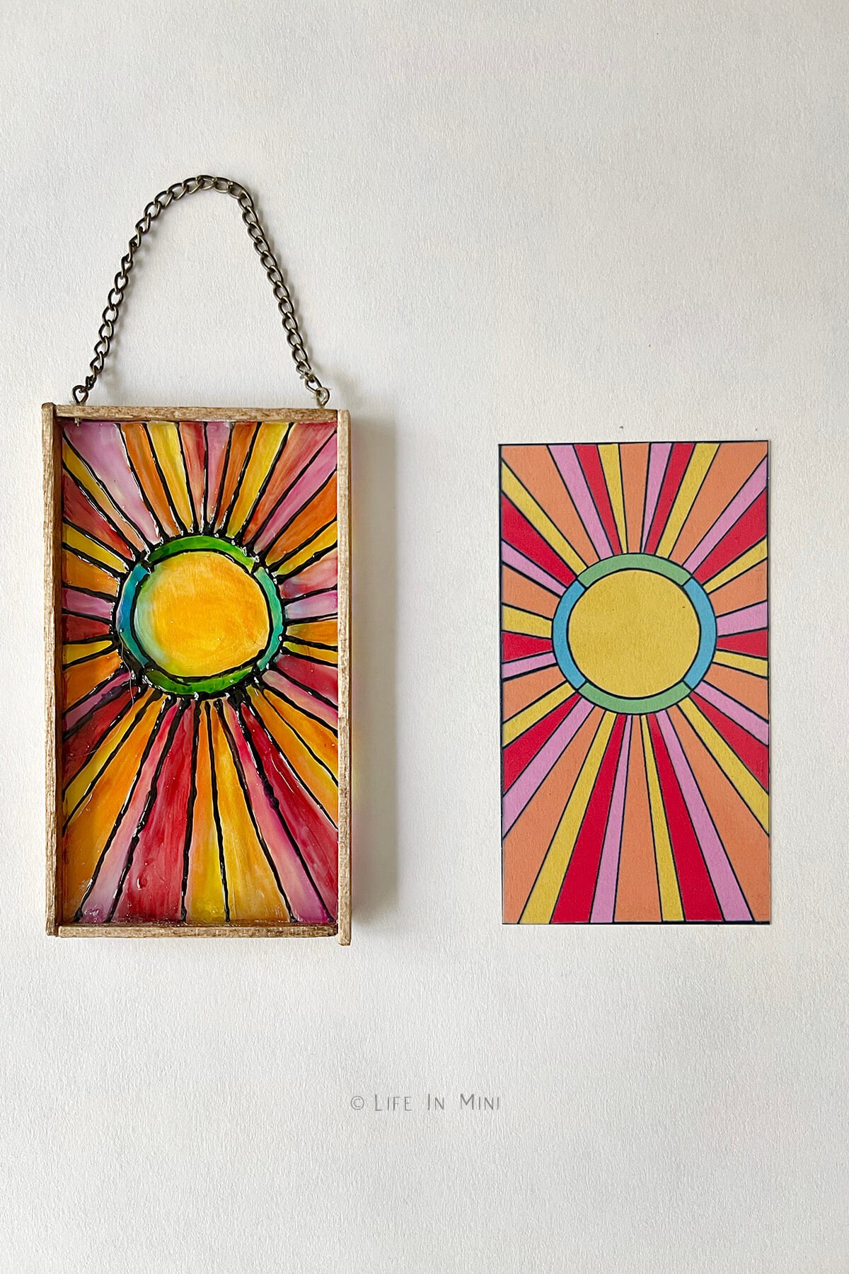 A miniature sun design stained glass made with glass paint next to the same design printed on transparency