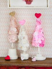 Closeup of three mini heart valentine trees sitting on top a dollhouse dresser.