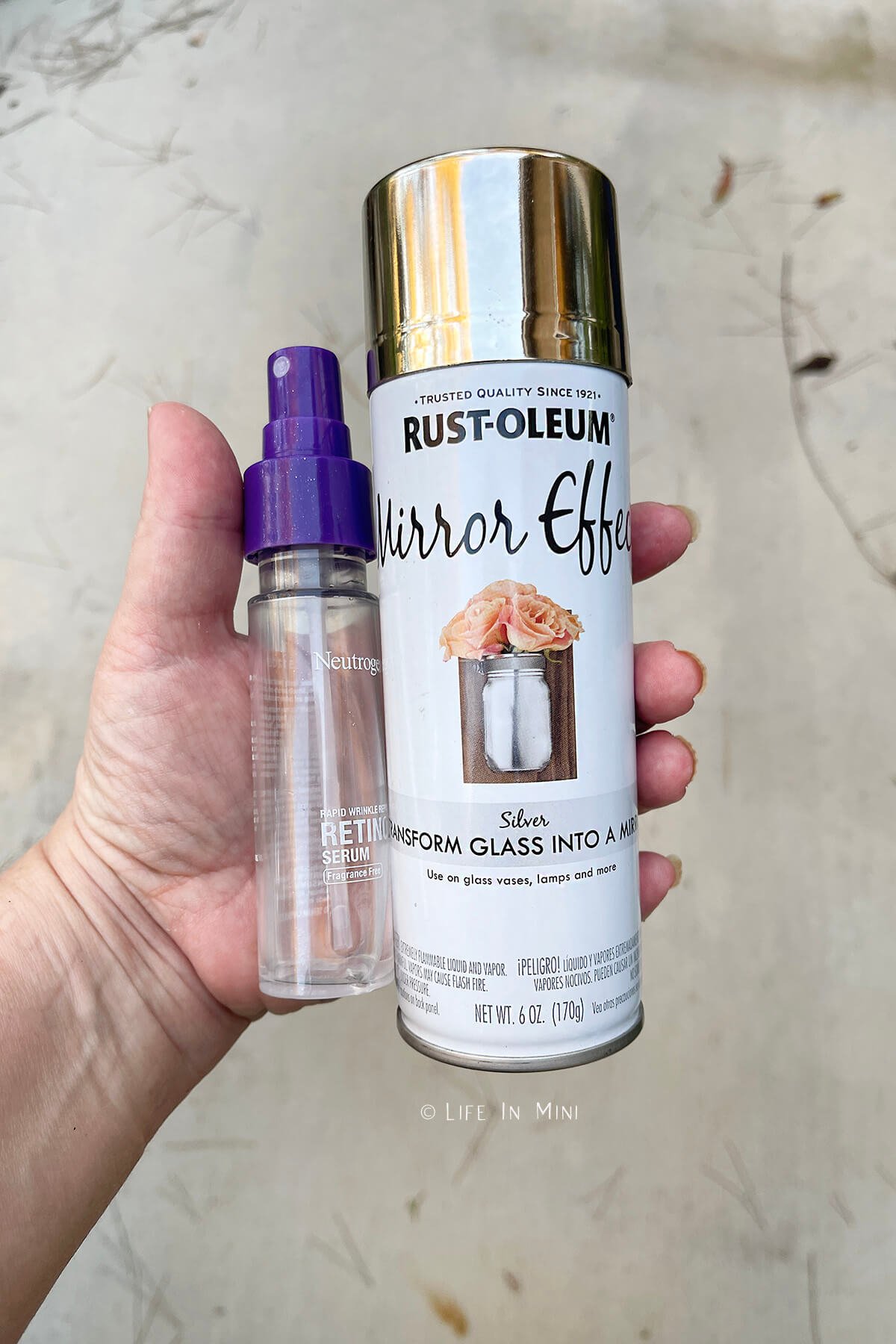 A hand holding a spray bottle with vinegar and mirror spray paint.