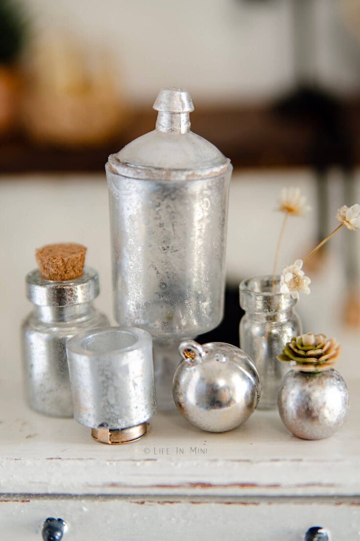 Closeup of assorted mercury glass miniatures for a dollhouse.