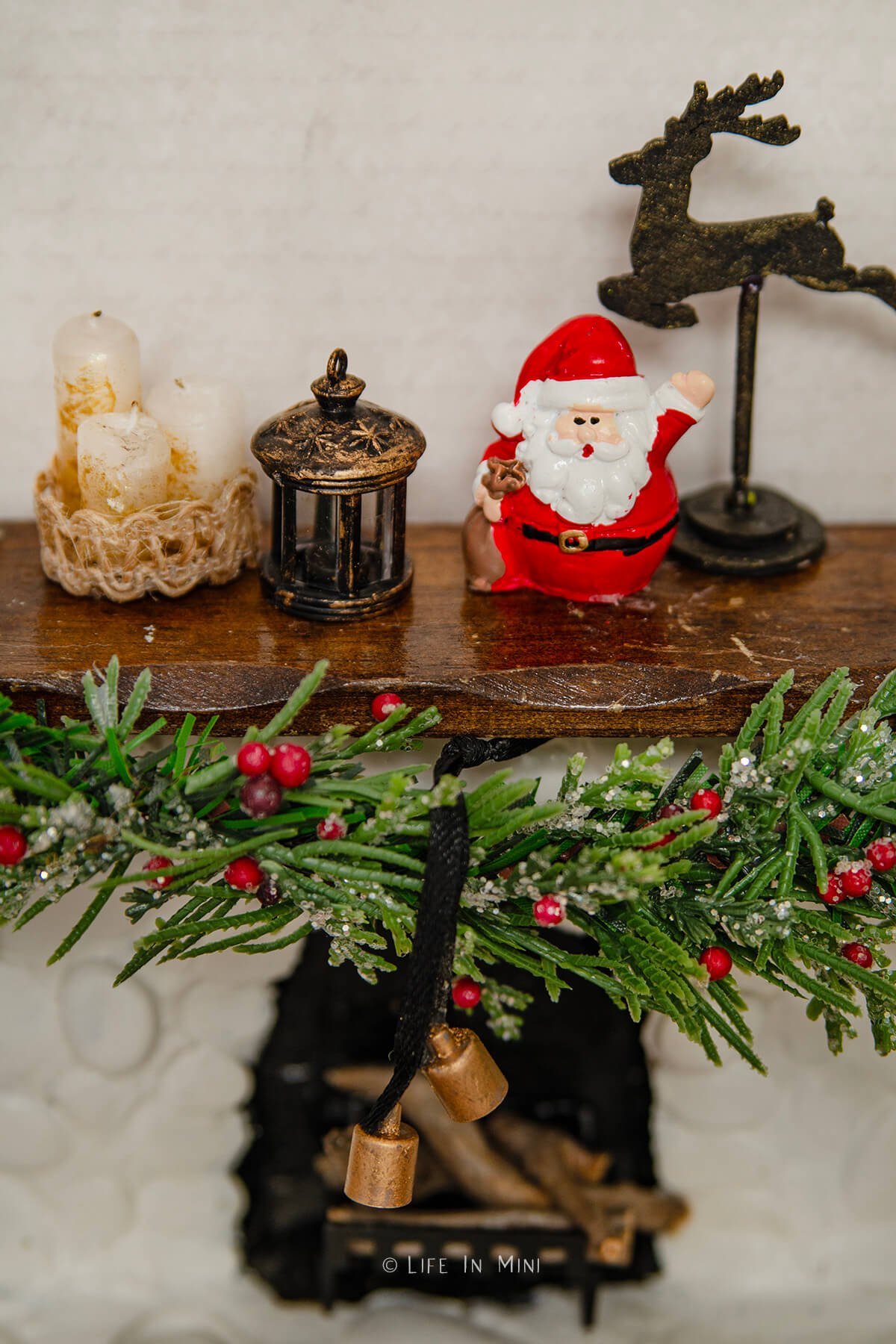 Closeup of Christmas decorations on a dollhouse fireplace mantle.