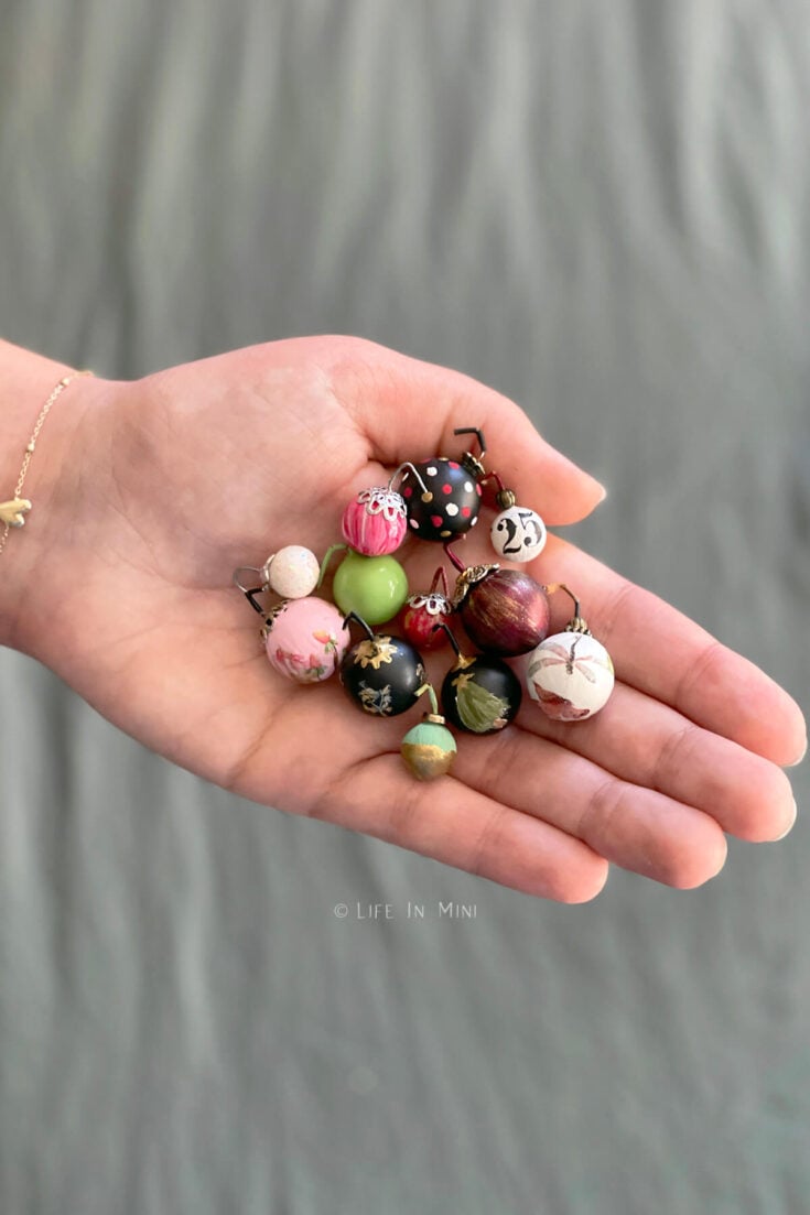 A hand hold assorted Christmas ball ornaments.
