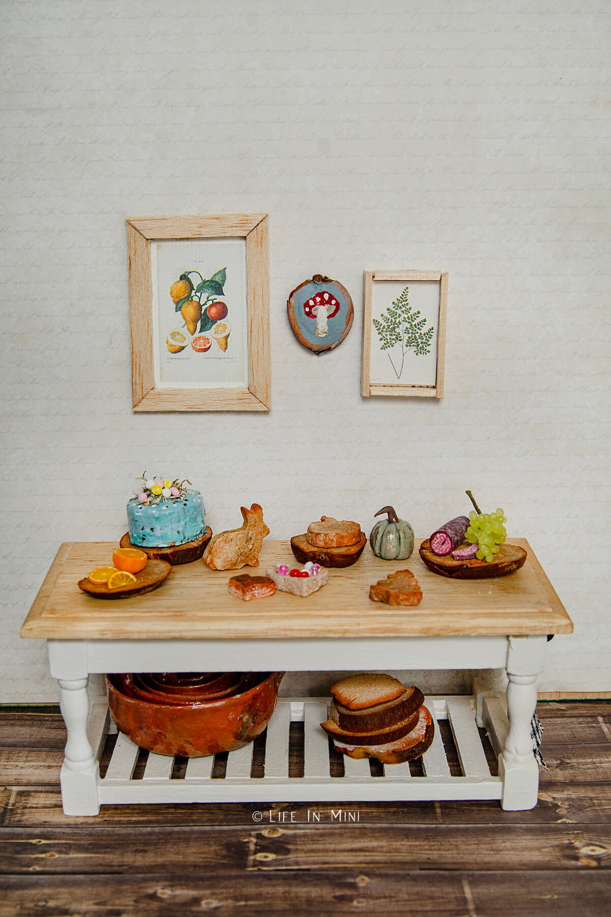 A dollhouse table with various things made from avocado pits like cutting boards and bowls.